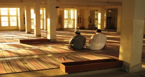 Two Muslim men are performing prayer.