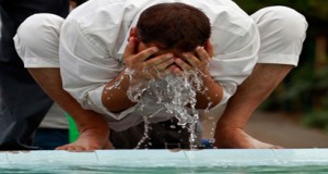 A person is performing Ablution with running water.