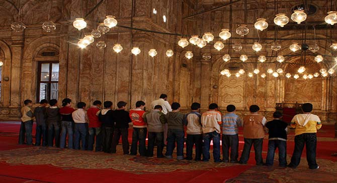 A group of Muslim children offer congregational prayer at a mosque - Standing Foot next to Foot in Prayer: Mandatory?